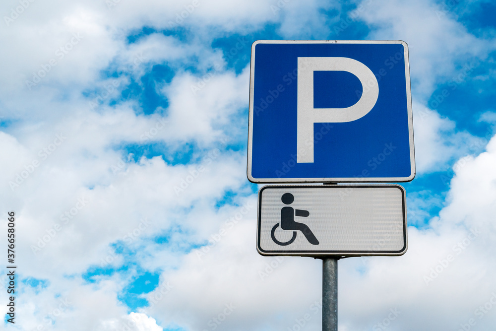Disabled parking sign with clouds in the background Disabled parking sign with clouds in the background