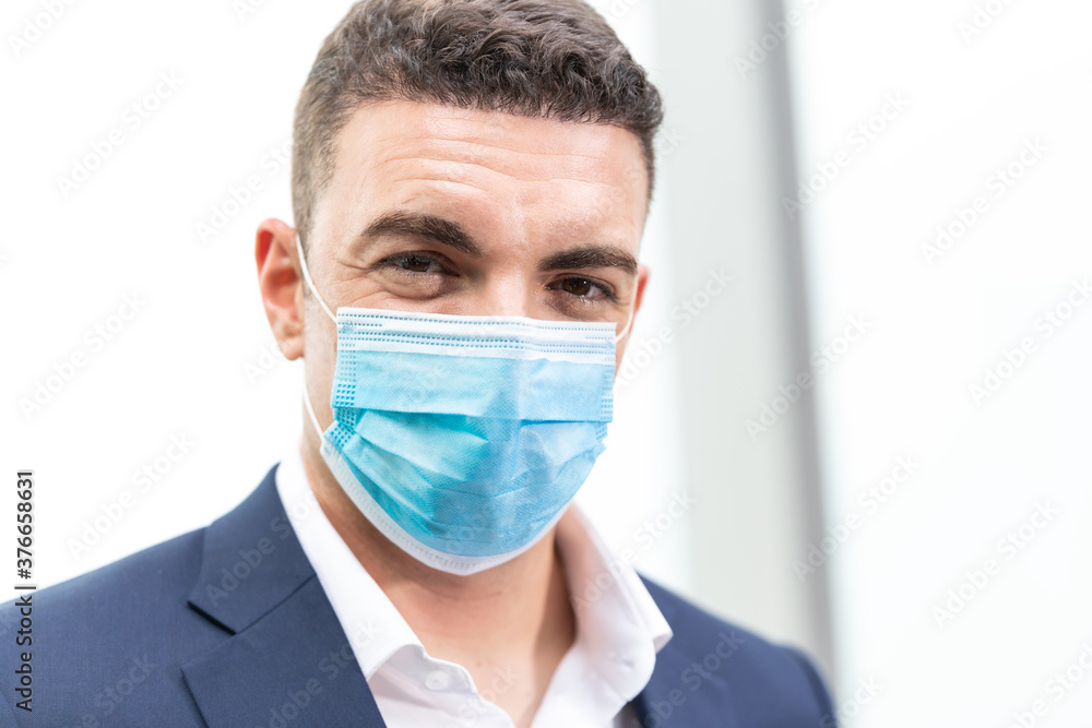 Portrait of Caucasian handsome business man wearing medical protective face mask to prevent Coronavirus or Covid19 looking at camera. concept for social distancing and new normal lifestyle. copy space Portrait of Caucasian handsome business man wearing medical protective face mask to prevent Coronavirus or Covid19 looking at camera. concept for social distancing and new normal lifestyle. copy space