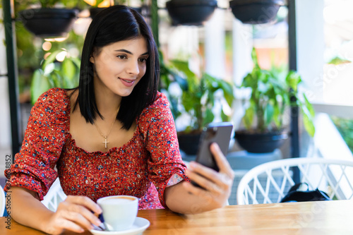 Young woman with smart phone in coffee shop