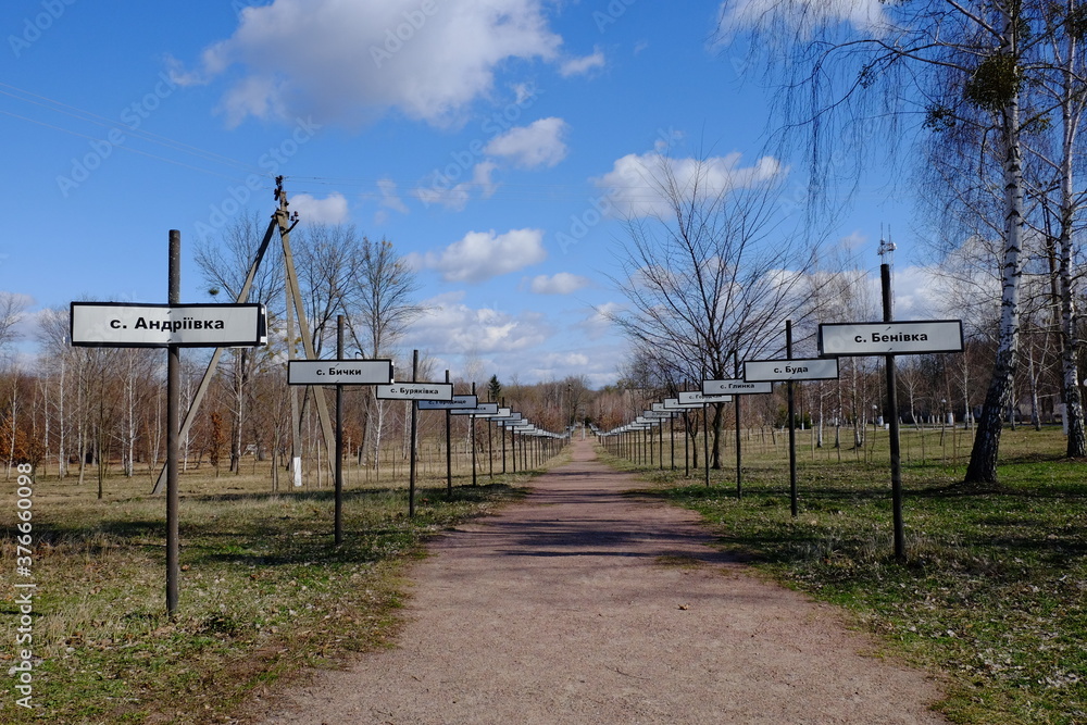 Alley with the names of abandoned villages in the zone of the Chernobyl nuclear disaster. Memorial complex to resettled villages in Exclusion Zone. Signposts with names of villages in Cyrillic.