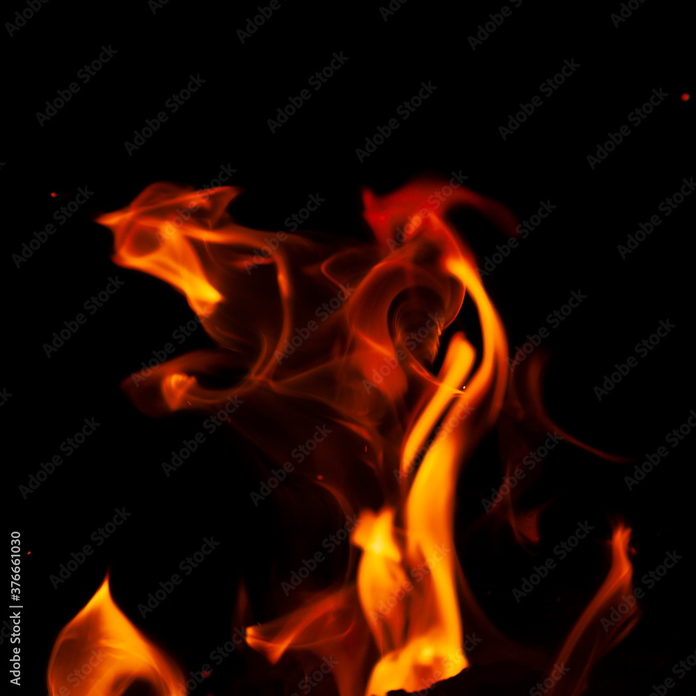 Fiery flame with sparks on a black background. Texture (element) for barbecue or cooking. Fiery flame with sparks on a black background. Texture (element) for barbecue or cooking.