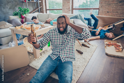 Photography Afro american man sit floor carpet touch head hand have migraine hold empty beer