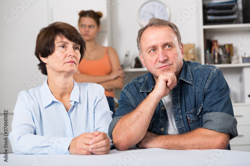 Adult couple is upseting and their daughter is sympathying with them at home.