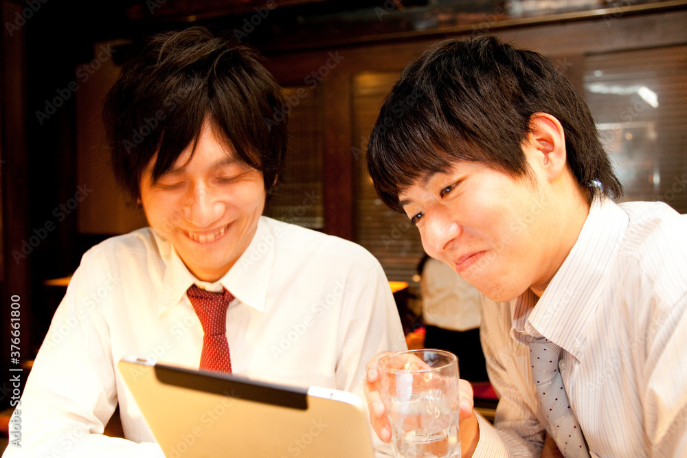 居酒屋でタブレットPCを持つビジネスマン 居酒屋でタブレットPCを持つビジネスマン