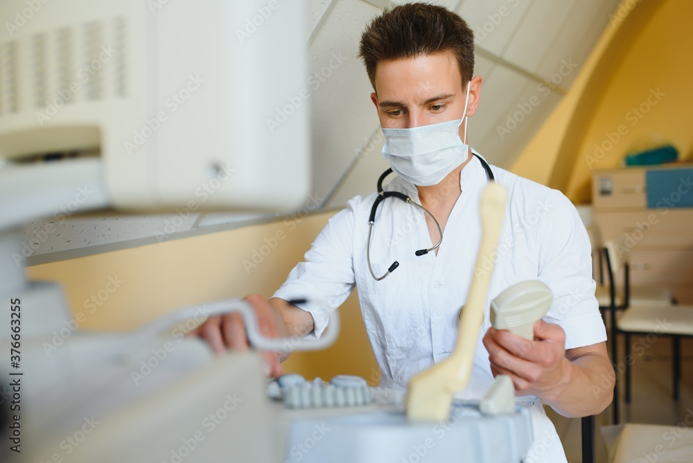 Portrait of young male technician operating ultrasound machine Portrait of young male technician operating ultrasound machine