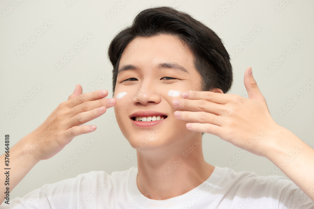 Young man with moisturizer on the face Young man with moisturizer on the face