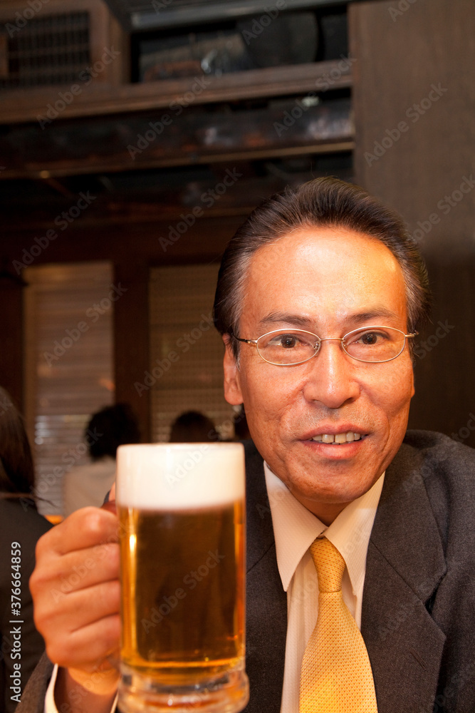 ビールを飲むビジネスマ人物、男性、日本人、会社員、男性社員、ビジネスマン、サラリーマン、居酒屋,飲食店,お酒,飲み物,飲む、ビール,ビールジョッキ、持つ、仕事帰り、ン
