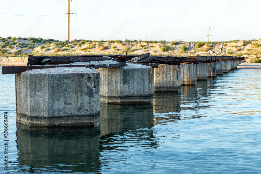 narrow sea against and remains of a bridge from one bank to another