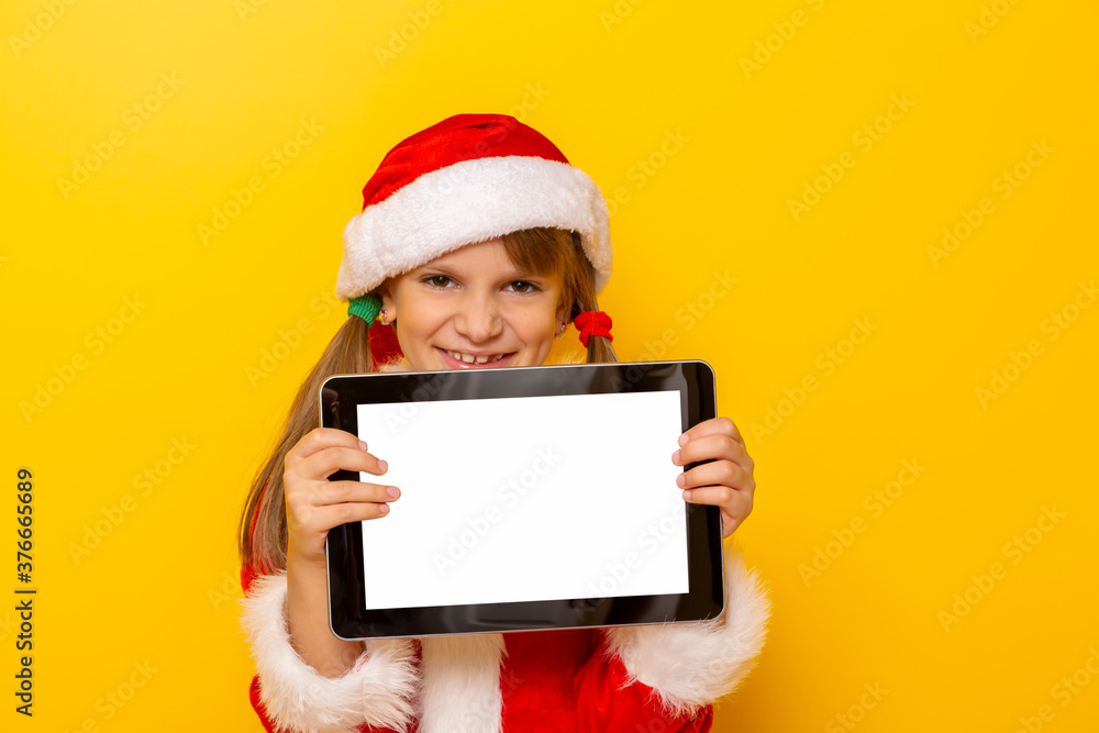 Little girl in Santa costume holding tablet computer Little girl in Santa costume holding tablet computer