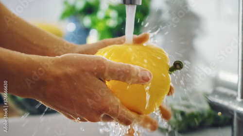 Close Up Shot of a Person Washing Yellow Sweet Pepper with Tap Water. Authentic Stylish Kitchen with Healthy Vegetables. Natural Clean Products from Organic Farming Washed by Hand.