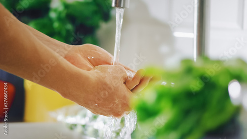 Close Up Shot of a Stylish Man Washing His Hands with Tap Water. Authentic Stylish Kitchen Sink with Healthy Vegetables. Natural Cleanliness at Home.