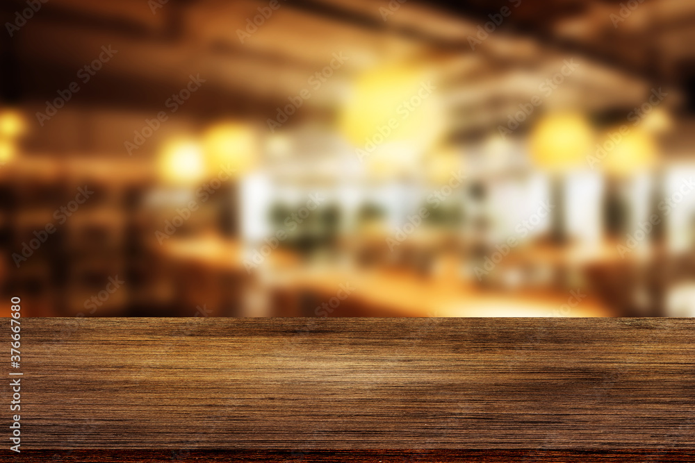 Side view of Empty space wooden table top with abstract blurry image of coffee shop or cafe restaurant in background for product showing and advertising.