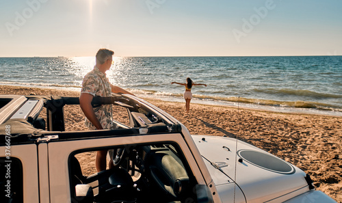 Couple on beach with car
