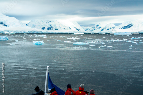 Antarctica, Antarctic Peninsula, Channel. Passenger on deck looking forward to enter the Lemaire Cahnnel.February 2020  photo