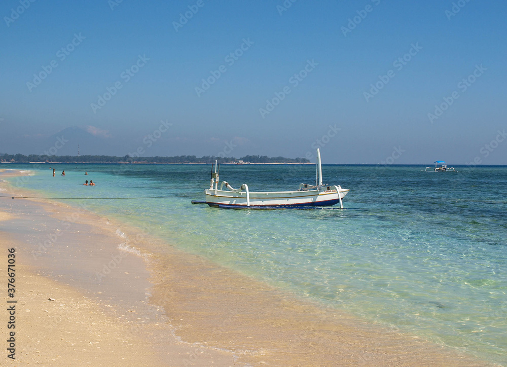 Paradise beach in blue tones with turquoise water, with  a boat on the shore