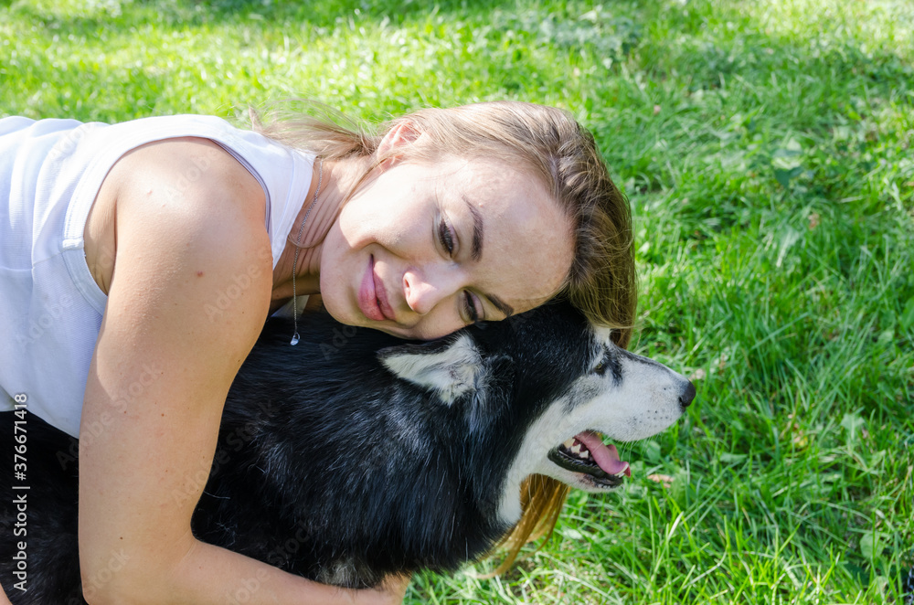 attractive blonde hugs her dog in the park. attractive blonde hugs her dog in the park.