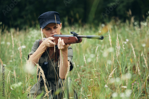 Woman With weapons in hand, shelter aiming green leaves green 