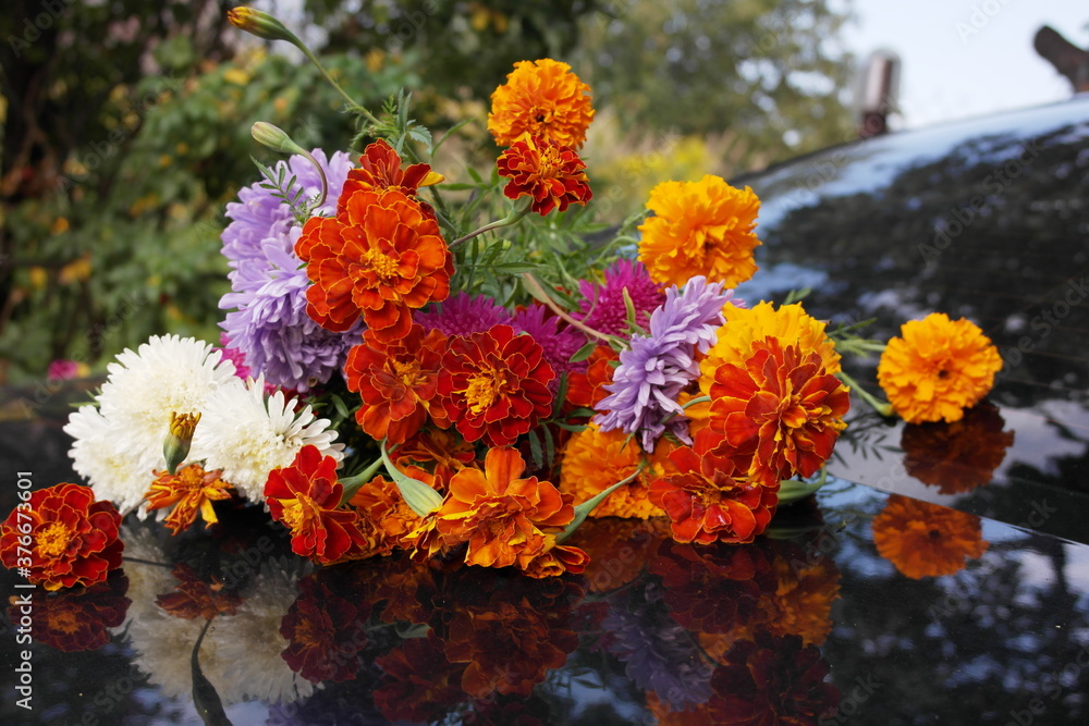 Autumn bouquet of bright flowers and its reflection