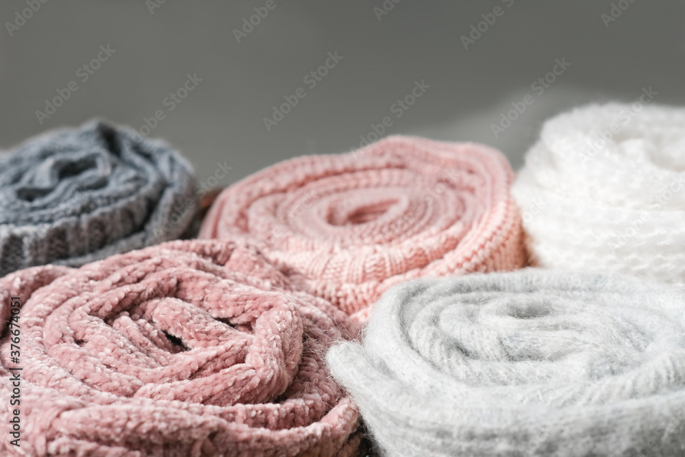 rolled knitted sweaters in grey and pink tones. autumn and winter warm pullovers. textured background. cozy clothes for cold season. rolled knitted sweaters in grey and pink tones. autumn and winter warm pullovers. textured background. cozy clothes for cold season.