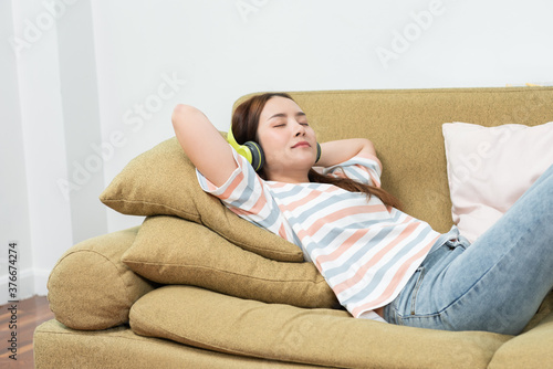 young woman listening to music with headphone at home