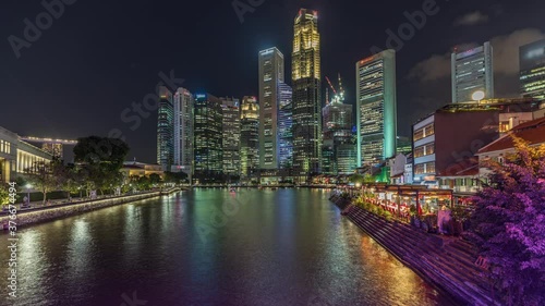 Singapore quay with tall skyscrapers in the central business district and small restaurants on Boat Quay day to night transition timelapse after sunset photo