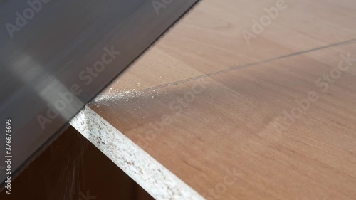 Man cutting a wooden board with a hand saw