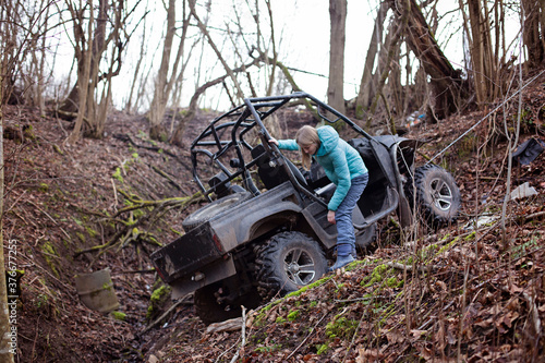 A woman checks the state of the buggy, which rolled down the hill into the ditch. Extreme ATV Riding