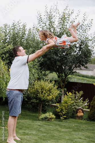 Young father throwing his baby daughter high in the sky in the park in summer day. father's day © Andriy Medvediuk