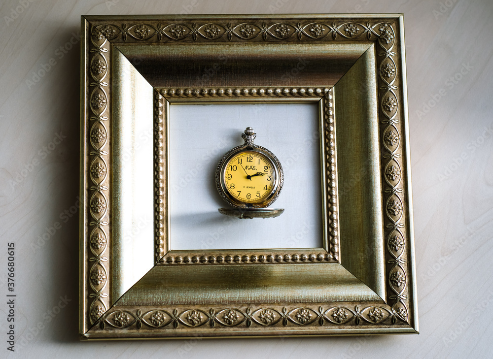 An old pocket watch made many years ago. Open antique clock in a gold baguette frame, as in the picture. The value of time. An old pocket watch made many years ago. Open antique clock in a gold baguette frame, as in the picture. The value of time.