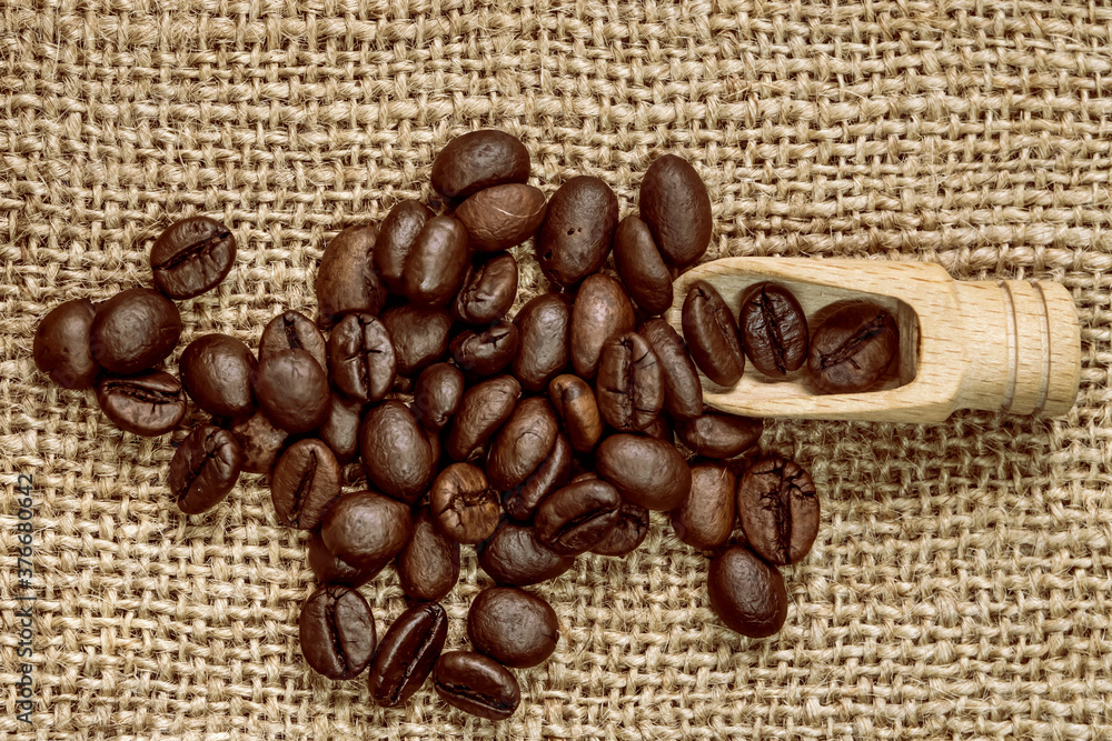 Coffee beans. Macro photo Burlap fabric. Wooden spoon for coffee. Rough fabric texture. Fabric Canvas. Coffee beans on sacking. Coffee abstraction. Coffee beans. Macro photo Burlap fabric. Wooden spoon for coffee. Rough fabric texture. Fabric Canvas. Coffee beans on sacking. Coffee abstraction.