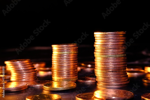 Stacks of gold money coin on black background and concept saving money 