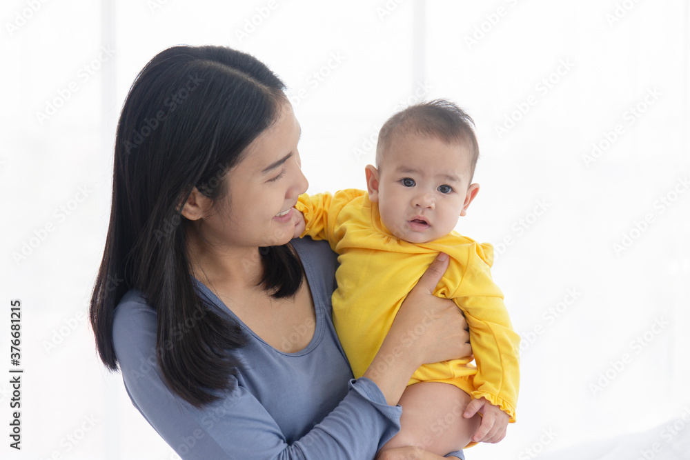 An Asian mother carries her baby with love and care. An Asian mother carries her baby with love and care.