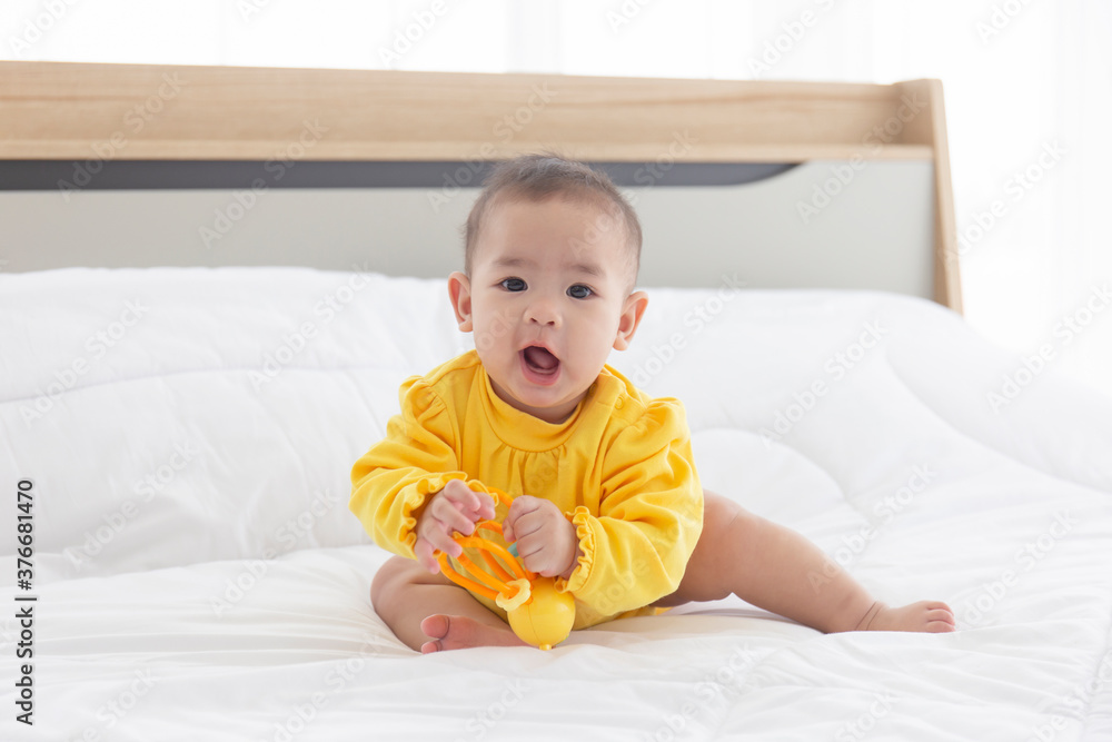Asian babies are playing baby toys in bed. Asian babies are playing baby toys in bed.