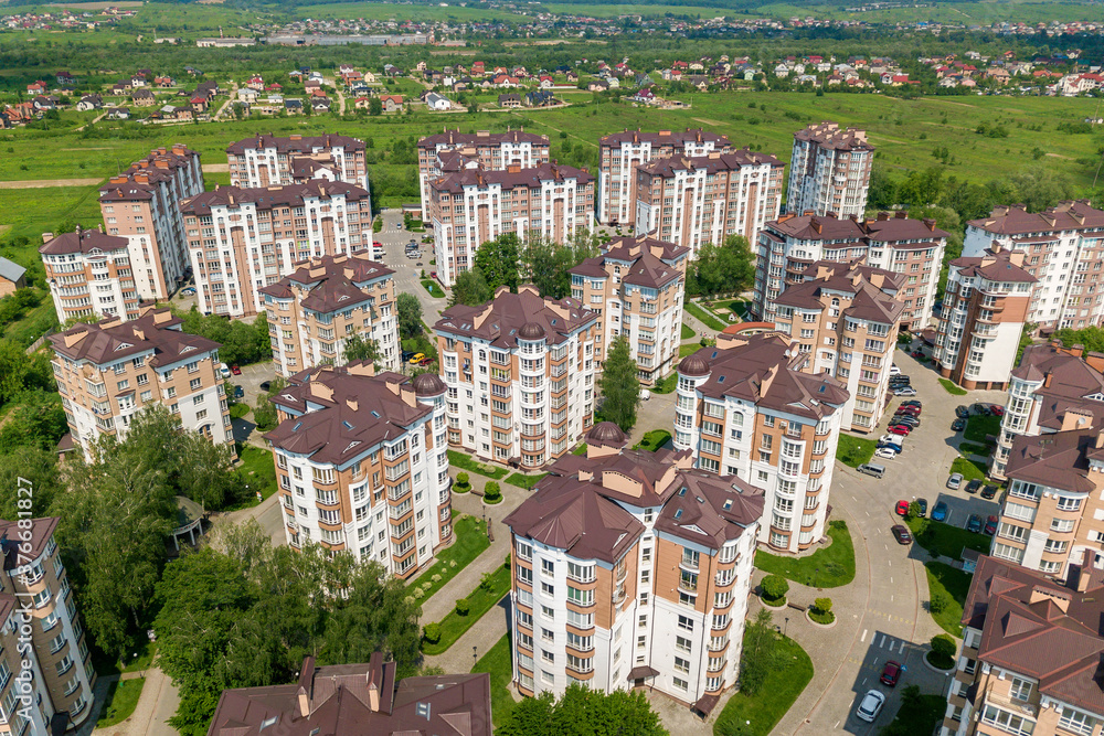 Fototapeta premium Top view of apartment or office tall buildings, parked cars, urban city landscape. Drone aerial photography.