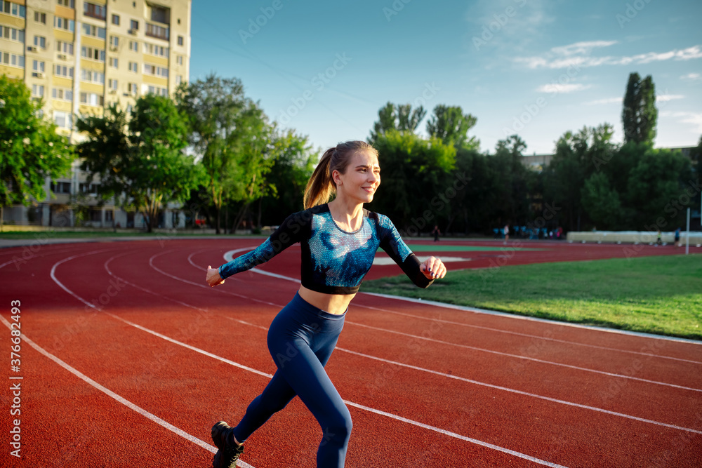 Woman running on treadmill in stadium