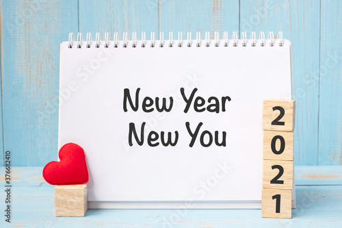 New Year New You words and 2021 cubes with red heart shape decoration on blue wooden table background. Goal, Resolution, health, Love and Happy Valentine’s day concept