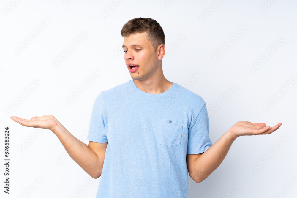 Young handsome man over isolated white background holding copyspace with two hands Young handsome man over isolated white background holding copyspace with two hands