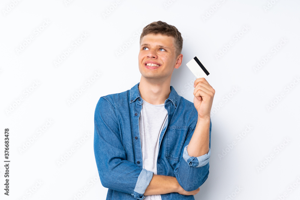 Young handsome man over isolated white background holding a credit card Young handsome man over isolated white background holding a credit card