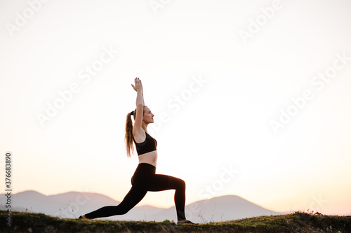Woman balanced, practicing meditation, zen energy yoga in mountains. Healthy lifestyle concept. Young girl doing fitness exercise sport outdoors. Morning sunrise. Relax in nature.