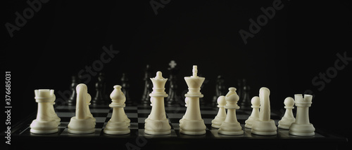 Game of chess. A row of white figures, black figures in the background. Waiting for the start. The concept of business strategy, startup, success. Depth of field