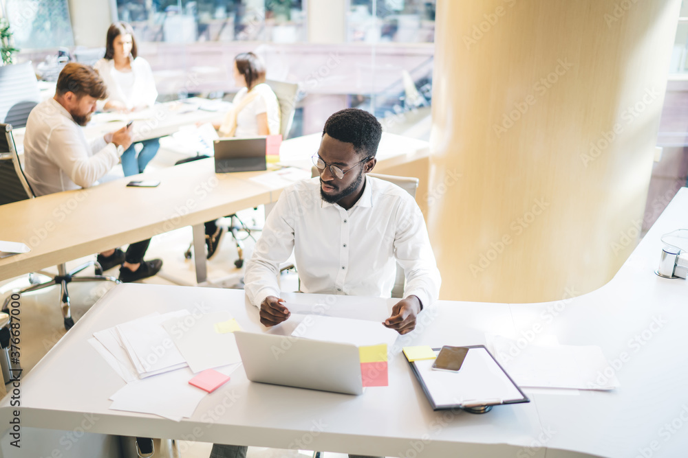 African American man working with papers in office