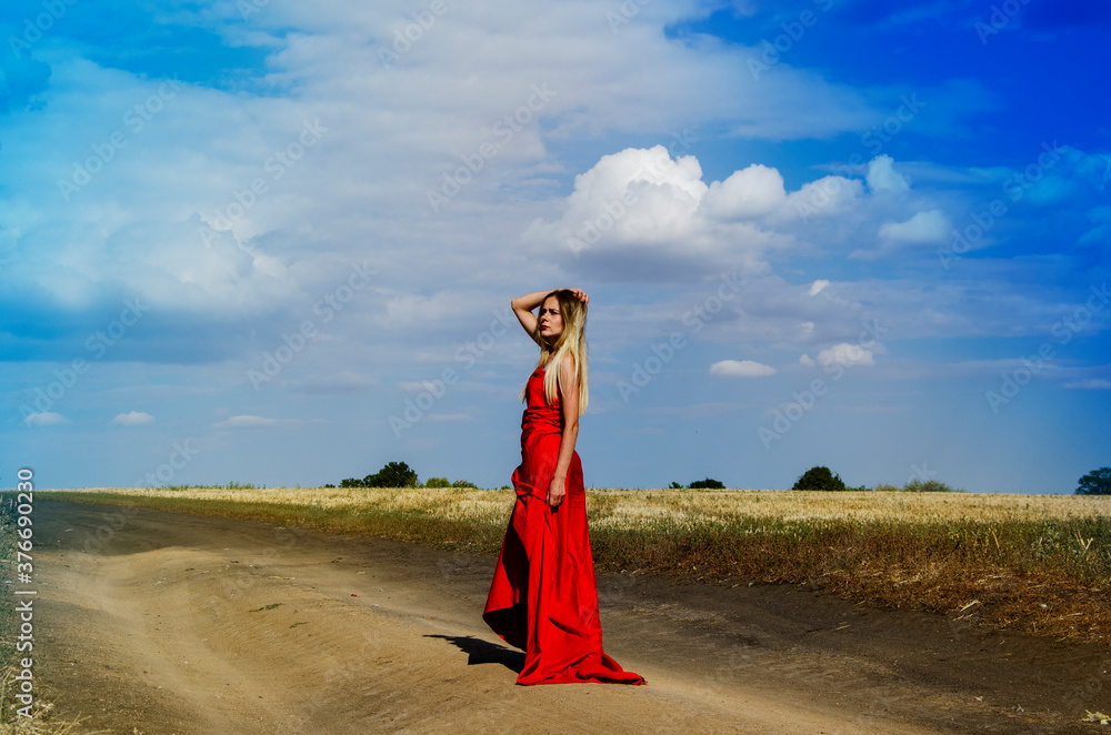Lady in a red dress. A beautiful girl in a long red dress walking along ...