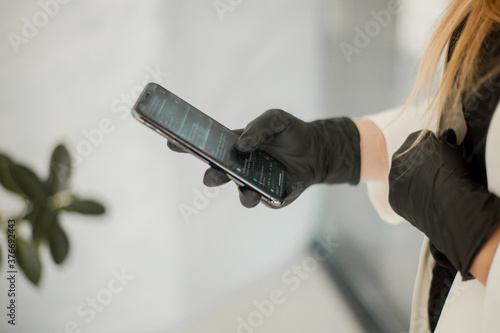girl in gloves holds a phone in his hands