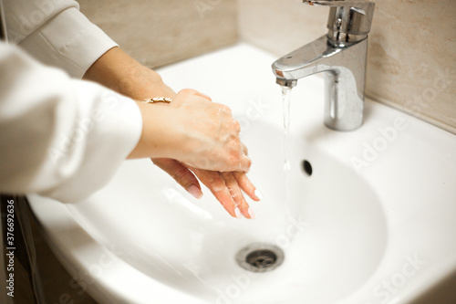 woman washes her hands from the covid virus