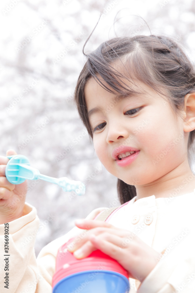 Naklejka premium シャボン玉で遊ぶ女の子