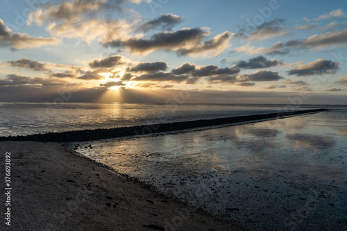 view on the wadden sea of the north sea at low tide at sunset near bernersiel