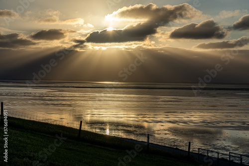 view on the wadden sea of the north sea at low tide at sunset near bernersiel photo