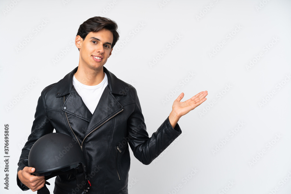 Man holding a motorcycle helmet over isolated white background holding copyspace imaginary on the palm Man holding a motorcycle helmet over isolated white background holding copyspace imaginary on the palm
