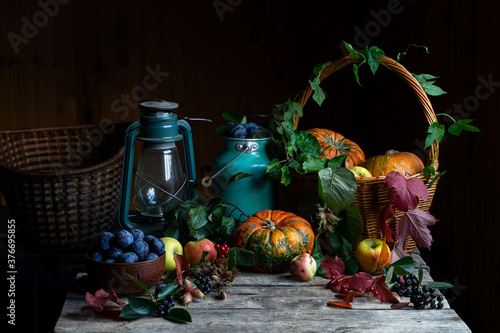 Still life with pumpkins, fruits, and berries on dark wooden rustic background