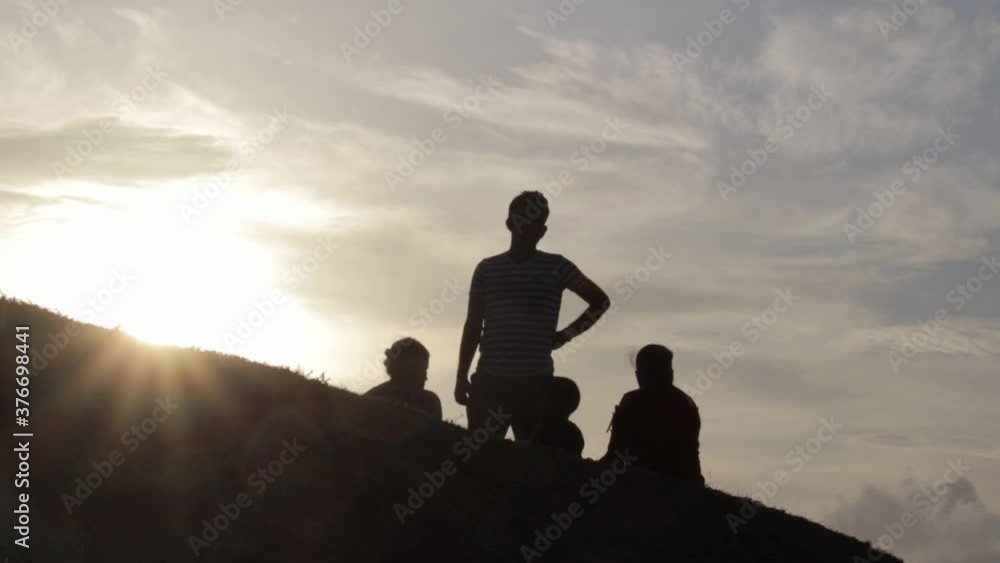 Silhouette of a happy family relaxing on the open grass field in Galle Fort evening sun glare, consept of a vacation and family time. Silhouette of a happy family relaxing on the open grass field in Galle Fort evening sun glare, consept of a vacation and family time.